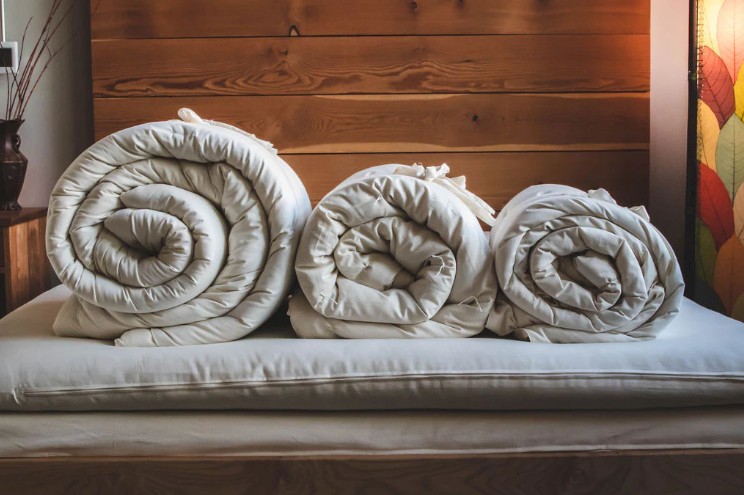 Stitched with care, you get warmth, temperature regulation, and breathability in this signature handmade product. Designed and handcrafted for comfort and coziness, our quilted comforters are made from domestically sourced premium eco wool encased in an organic cotton sateen shell. Hand-tufted and stitched around the perimeter so the wool batting stays in place. Now with corner ties for securing into your duvet cover. These comforters naturally regulate body temperature while wicking away moisture, ensuring