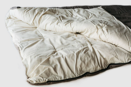 Like our classic wool bedding items, we choose only the best materials, with the added element of outdoor durability. Made with an organic cotton sateen lining in an organic cotton canvas outer shell and filled with a generous amount of breathable, domestically sourced premium eco wool batting. Hand tufting keeps the wool securely in place. YKK snag-resistant zipper around the side and lower edge. Two sleeping bags of the same size can be zipped together for partner sleeping.