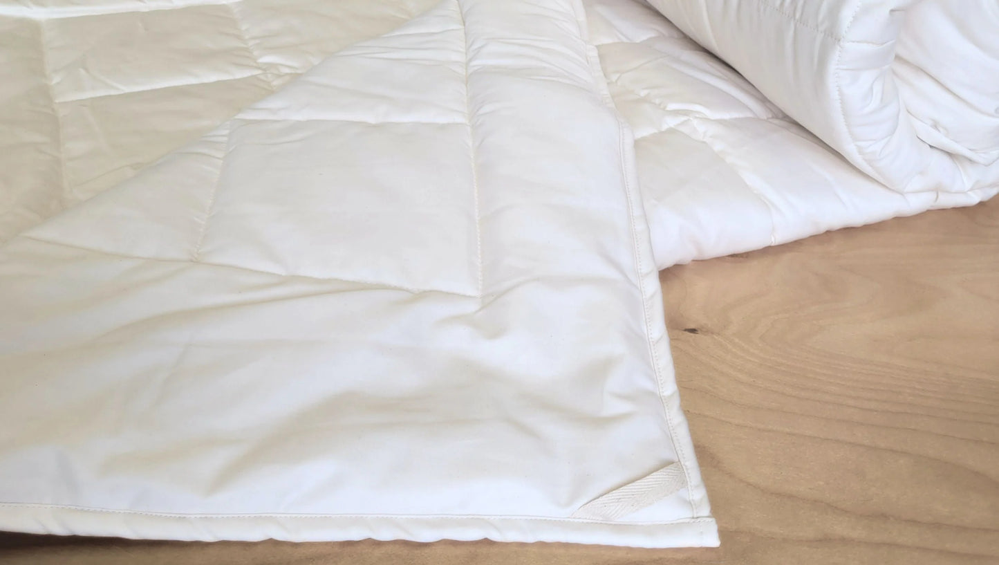 Soaring Heart's quilted organic cotton comforter is designed and crafted for our customers to achieve a restful sleep. The inner filling is made from our blend of certified organic cotton, and encased in a GOTS certified cotton fabric. The artisan quilting pattern keeps everything in place and makes this comforter extremely durable. This comforter is recommended for someone who sleeps cold, or prefers a more weighted comforter.