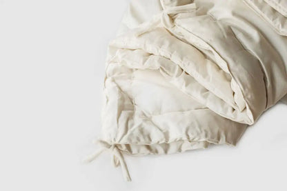 The perfect option to carry you through all four seasons.Two comforters, each slightly lighter than our Light weight, joined together with cotton ties at the corners and on the sides. Tie the layers together in colder weather, separate them as the temperature warms. Fits insidea duvet cover with ease. Designed and handcrafted for comfort, warmth, and coziness, our quilted comforters are made from domestically sourced premium eco wool encased in an organic cotton sateen shell. Hand-tufted and stitched around