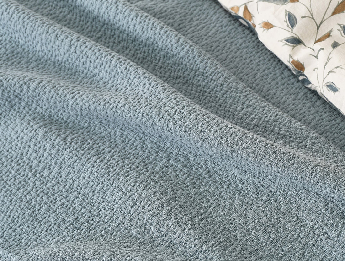 Crafted in Portugal from exceptionally fine yarns, this matelass√© blanket pairs a light, lofty feel with a high performance, stitched texture. Inspired by quilted kantha cloth, each blanket is stonewashed to enhance the raw beauty and softness of rumpled organic cotton. Finished with a simple bound edge for heirloom detail and effortless layering.