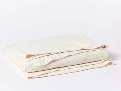 Crafted in Portugal from exceptionally fine yarns, this matelass√© blanket pairs a light, lofty feel with a high performance, stitched texture. Inspired by quilted kantha cloth, each blanket is stonewashed to enhance the raw beauty and softness of rumpled organic cotton. Finished with a simple bound edge for heirloom detail and effortless layering.