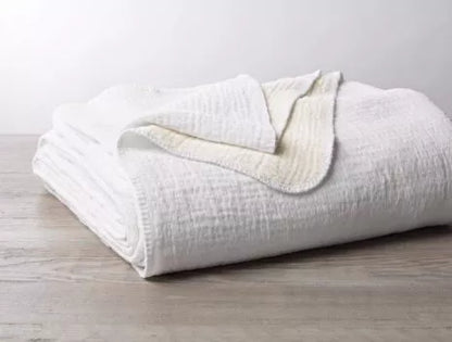 Indulge in luxurious comfort with the Coyuchi Cozy Cotton blanket, harmonizing plush chenille with lightweight organic cotton for a delicately puckered texture. Each color reverses to white, offering versatile decoration options. Crafted from 100% organic cotton, sourced in Turkey and expertly woven in Germany, this blanket promises both elegance and ease with its machine-washable design (please refer to washing instructions).
