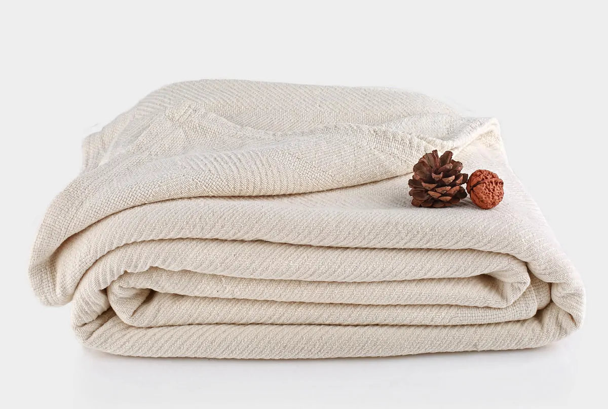 Indulge in the comforting embrace of the Organics And More Organic Cotton Chenille blanket. Meticulously crafted with hemmed edges and a charming herringbone pattern, this mid-weight blanket offers both texture and warmth. Made from GOTS certified organic cotton in a soothing ivory hue, it’s not only machine washable but also gets softer with every wash. Enjoy the durability and cozy comfort of this healthy alternative to conventional cotton blankets.