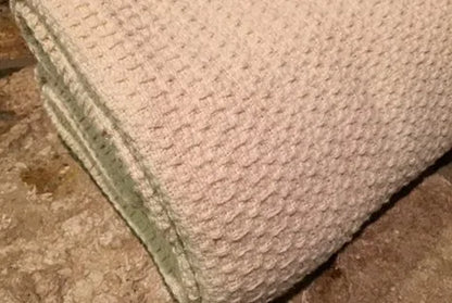 Experience year-round comfort with our Organic Waffle Weave Blanket, featuring a soft, lightweight design for cozy versatility. Crafted from GOTS certified organic cotton, this blanket offers both style and sustainability. Its loose waffle weave provides enhanced flexibility and breathability, perfect for all seasons. Whether draped over your bed or used as a stylish throw, its natural ivory color and hemmed edges add a touch of elegance to any space. Plus, it’s conveniently machine washable for easy care.