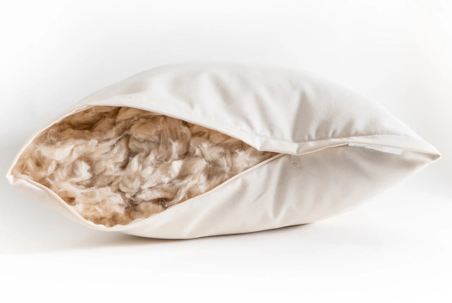 This pillow is made from soft silky kapok covered in organic cotton sateen. Kapok is a silky fiber, and feels much like milkweed or down. It is harvested from the seed pods of a kapok tree (the tree is never cut down). This natural pillow will compress with use but can be placed dry in a hot dryer for 10 minutes to help plump the pillow. This is our softest feeling pillow. Comes with a zipper so you can add or remove filling.