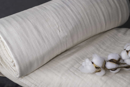 Indulge in the ultimate comfort with our organic blanket, crafted from four layers of luxurious double gauze GOTS-certified organic cotton muslin. Uniquely designed for breathability and softness, it’s free of harmful chemicals and dyes, ensuring a soothing and safe sleep environment. With a relaxed, crinkled style, this blanket offers exceptional airflow and becomes even softer and cozier with each wash. Choose from four delightful color options to suit your style and enhance your bedding ensemble.