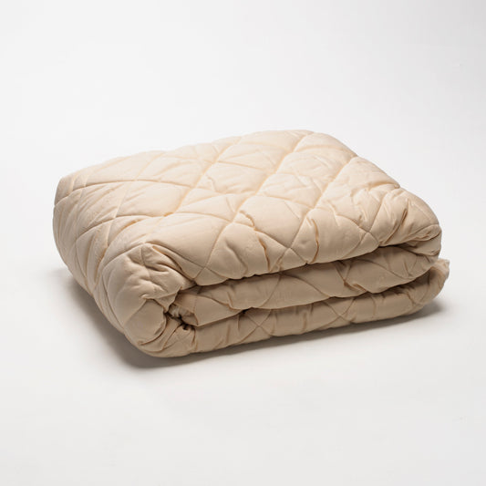 The washable wool mattress pad is made of our American Dream Wool and quilted using organic cotton on both sides. It provides excellent protection to your mattress. The washable wool pad is skirted with organic cotton knit and features an 18" pocket. It will keep your mattress looking newer longer. Made in the USA.